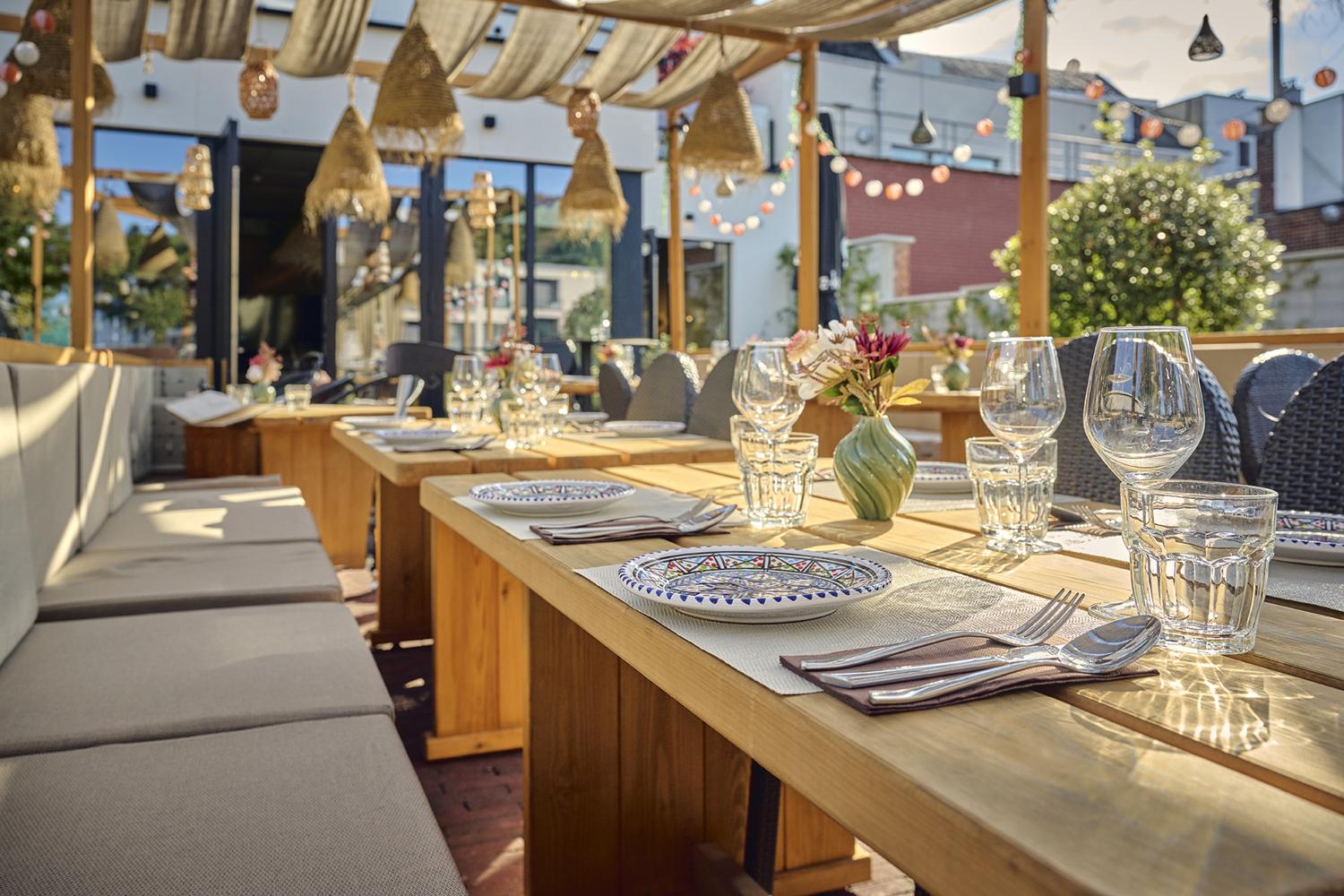 Lange houten terrastafels met beschilderde borden