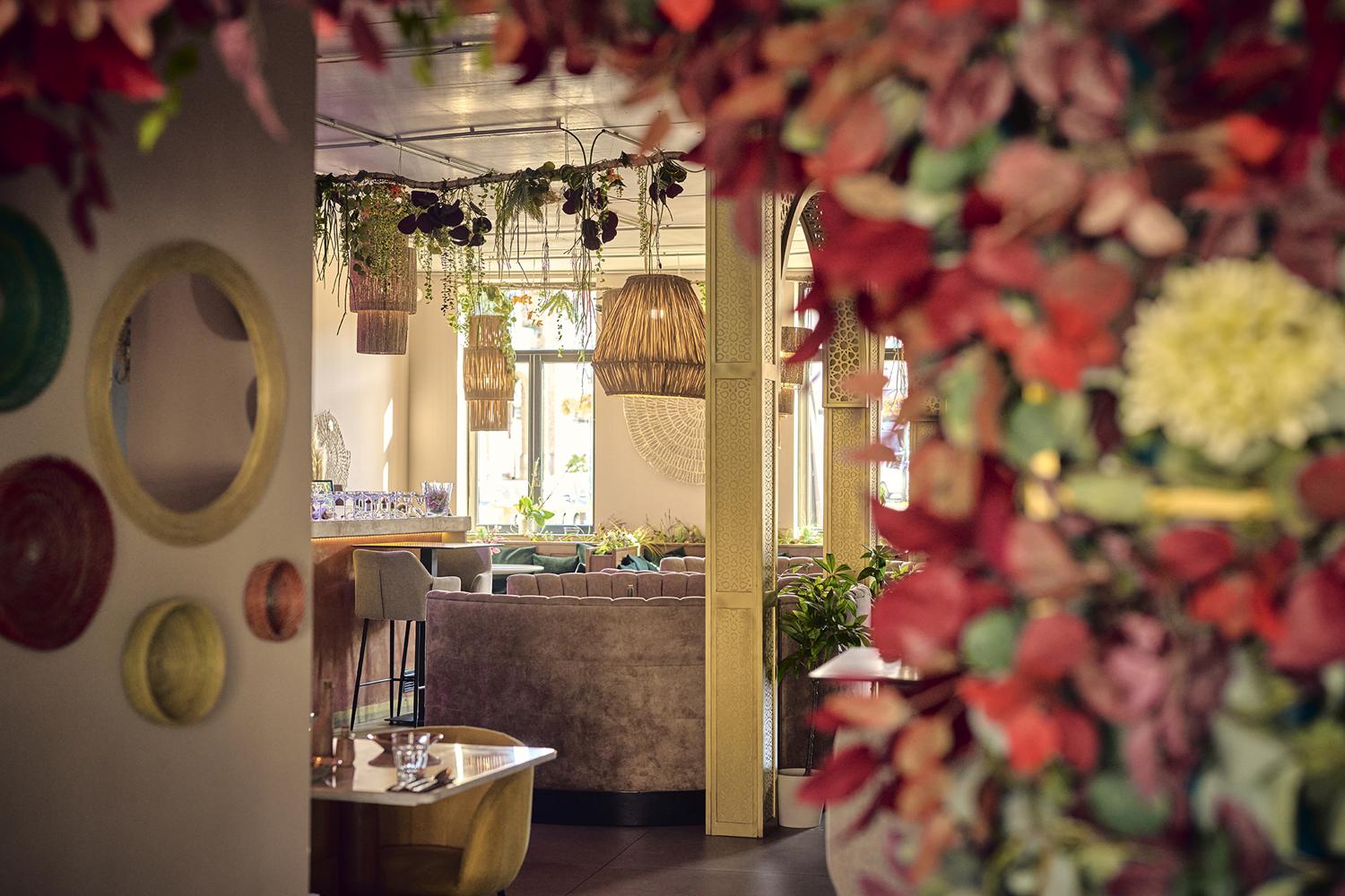 Zicht door bloemen op de gouden boog en de bar