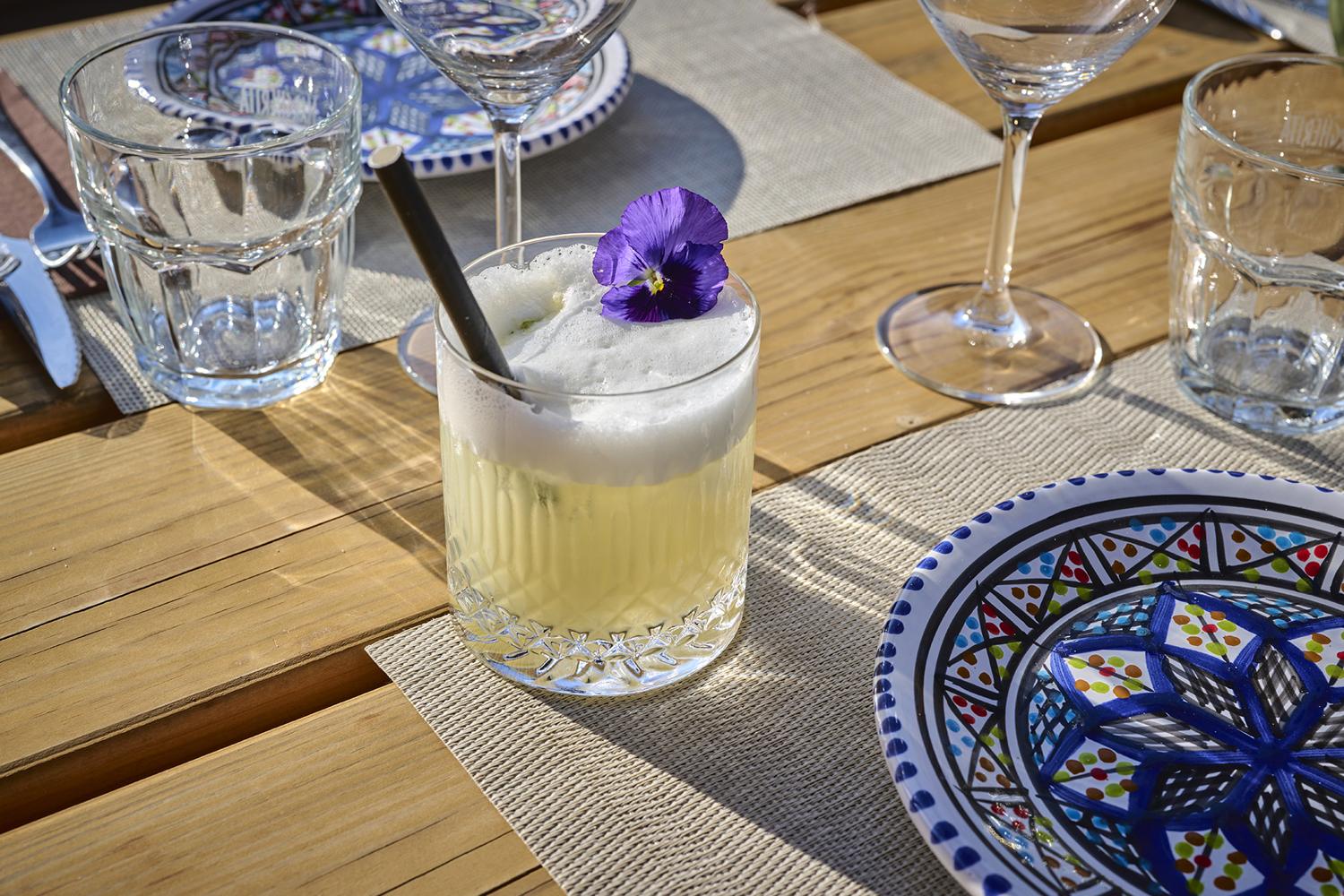 Cocktail met schuimkraag en een paars viooltje